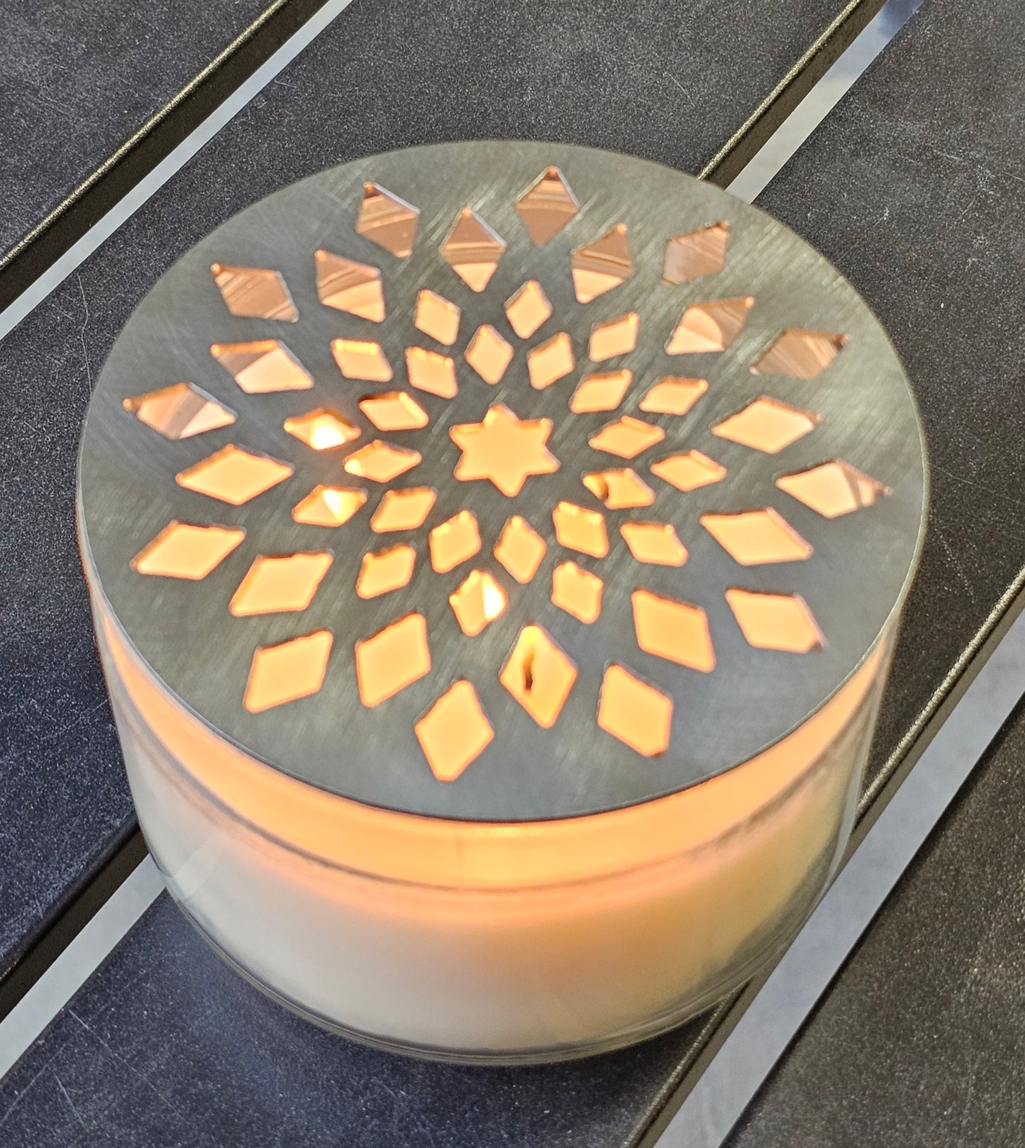 Decorative candle holder with geometric pattern on a dark surface