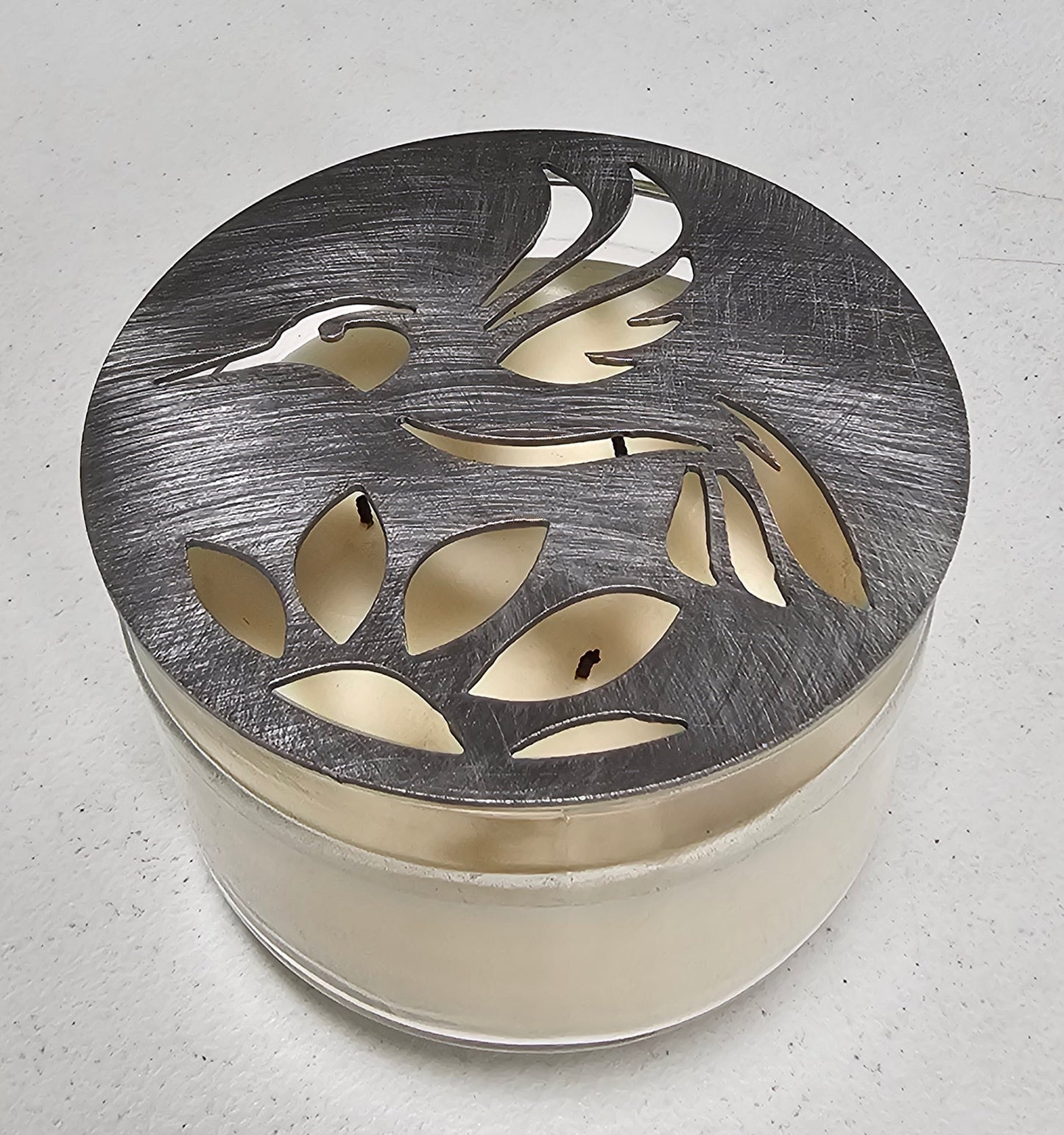 Hummingbird metal candle topper on 3-wick candle with cutout leaf design
