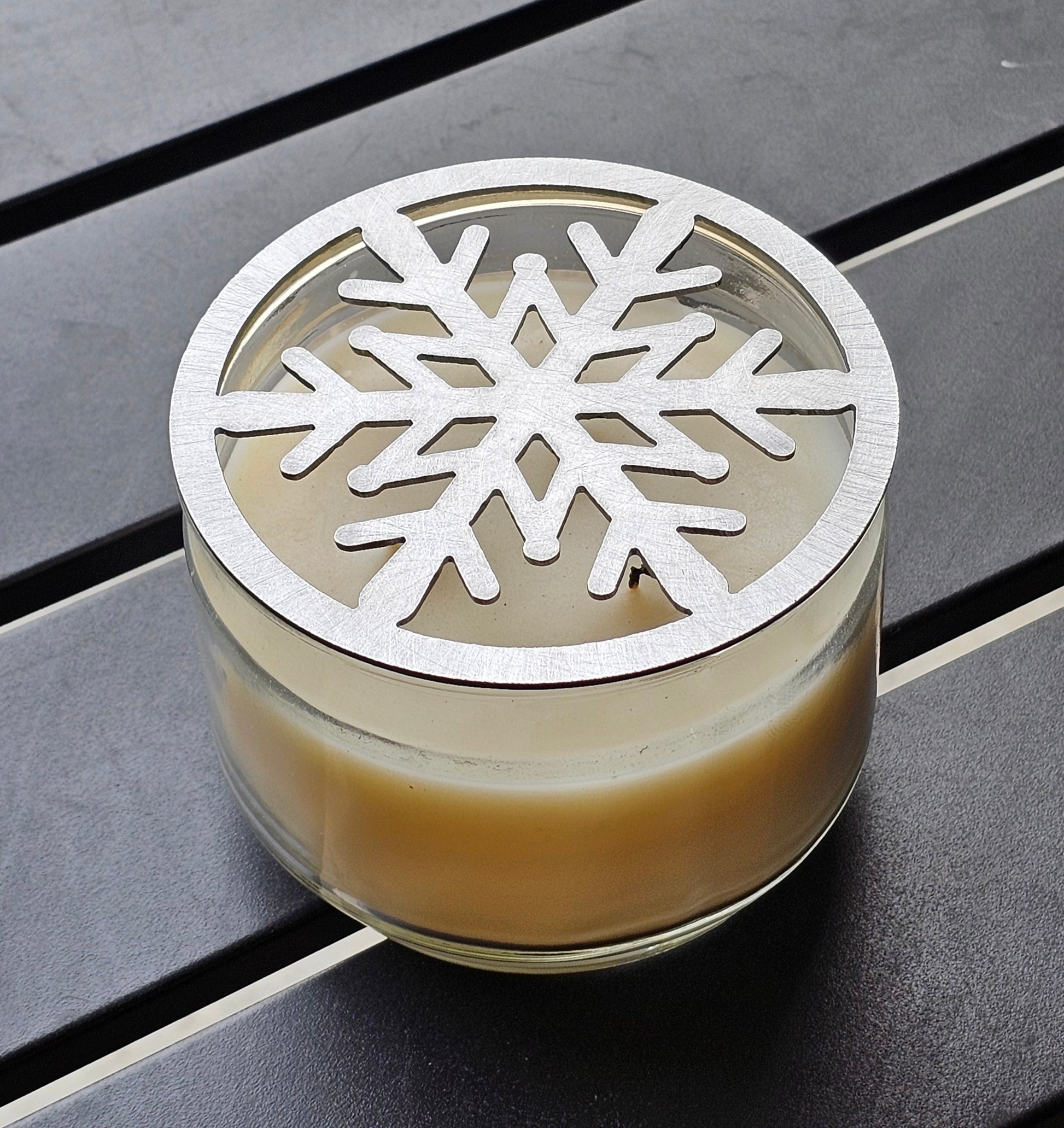 Metal snowflake candle topper on jar candle for Christmas decor