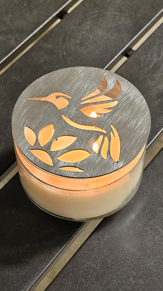 Hummingbird metal candle topper on 3-wick candle with cutout leaf design