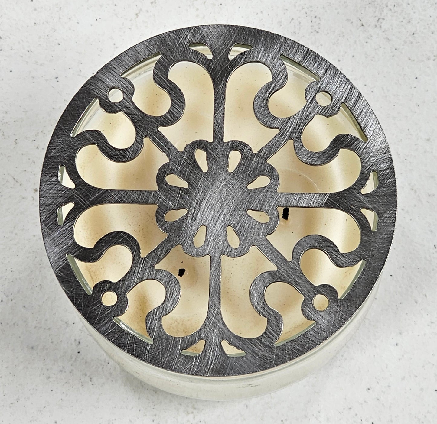 Victorian Scroll metal candle topper on a lit jar candle featuring ornate vintage scrollwork design