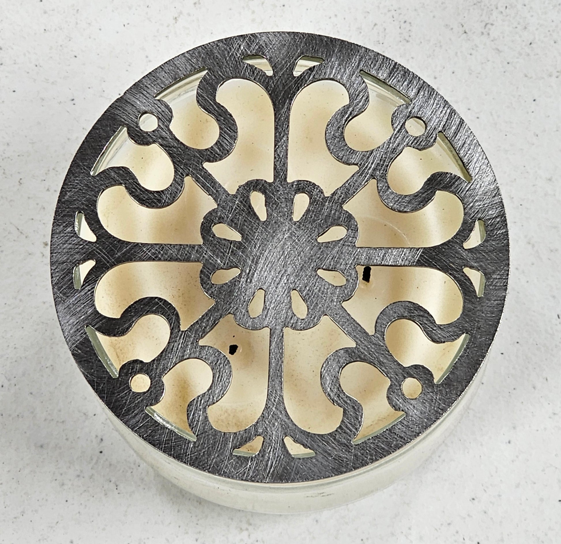 Victorian Scroll metal candle topper on a lit jar candle featuring ornate vintage scrollwork design