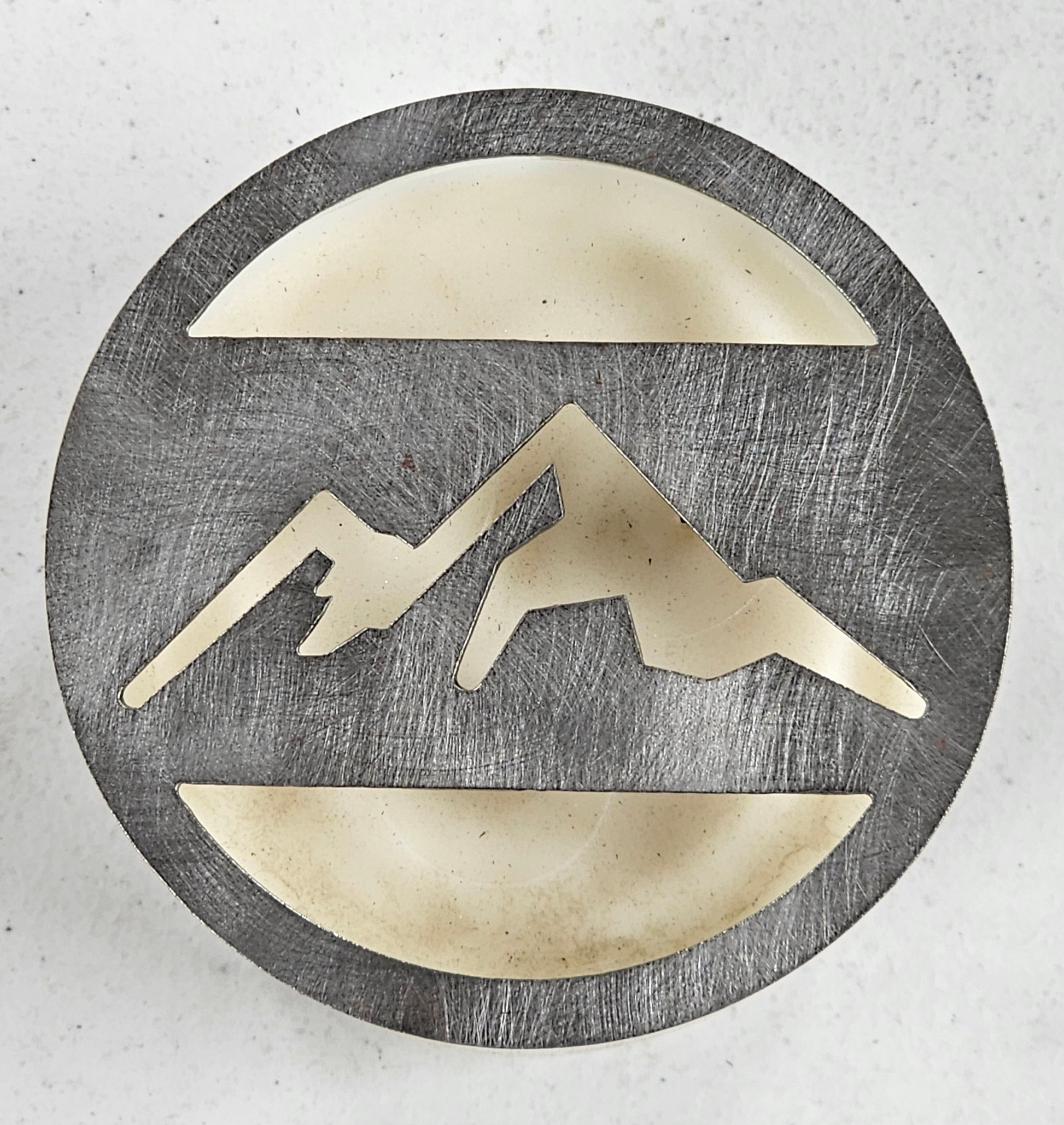 Mountain metal candle topper placed on white jar candle