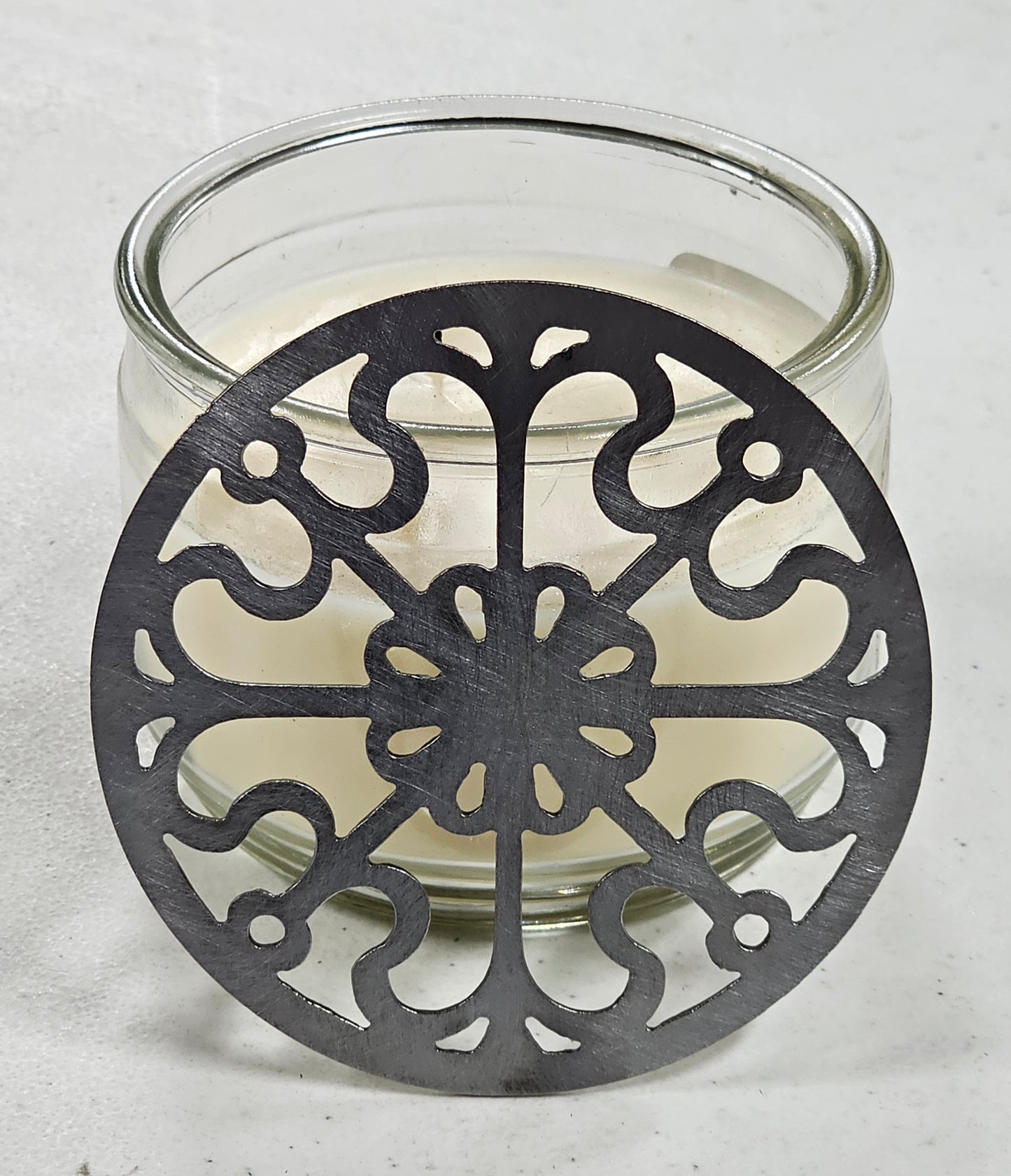 Victorian Scroll metal candle topper on a lit jar candle featuring ornate vintage scrollwork design