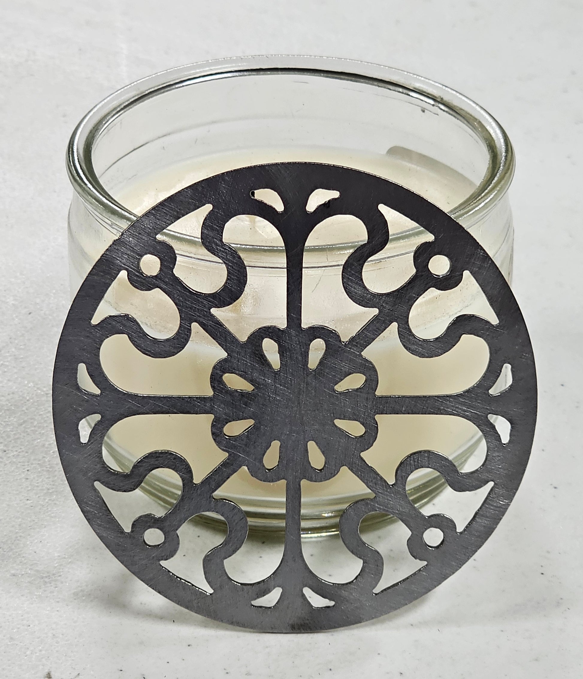 Victorian Scroll metal candle topper on a lit jar candle featuring ornate vintage scrollwork design