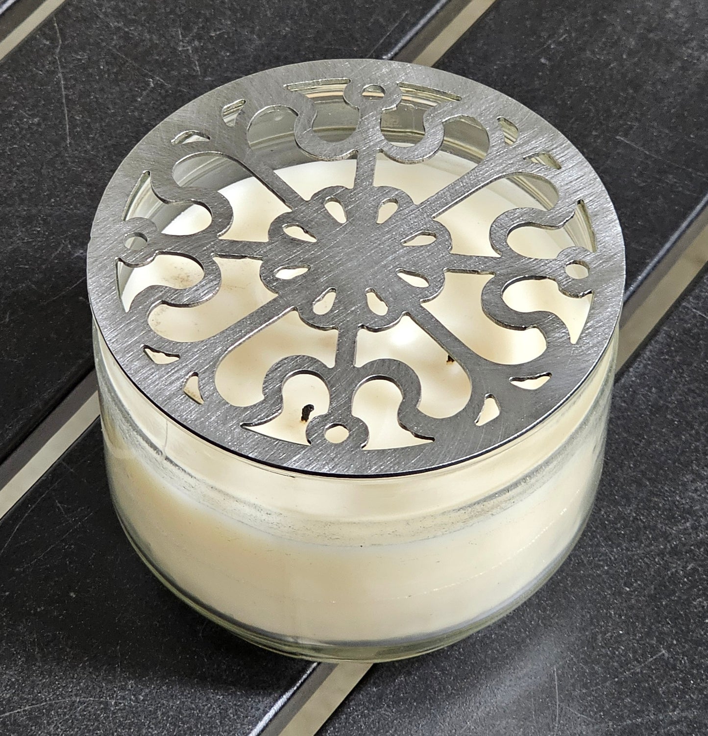 Victorian Scroll metal candle topper on a lit jar candle featuring ornate vintage scrollwork design