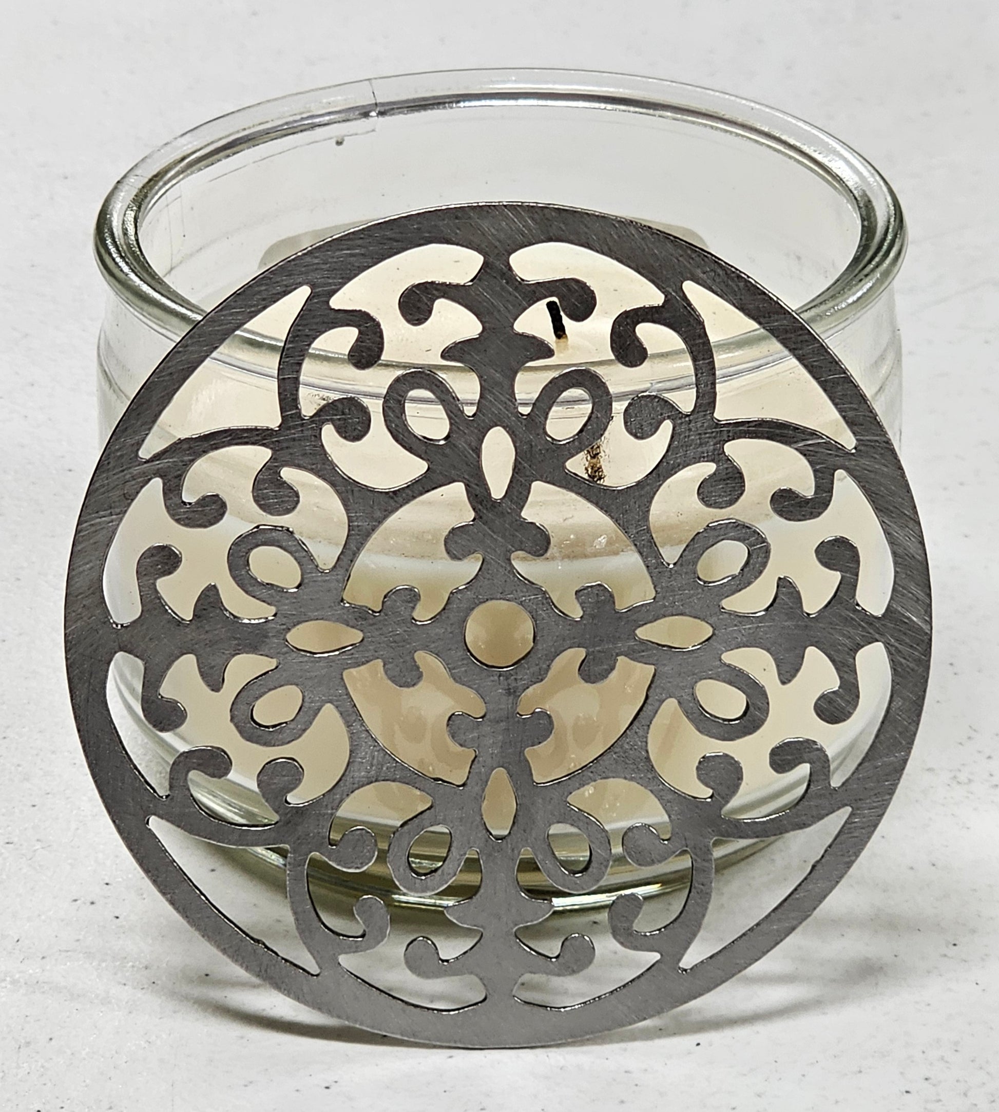 Vintage baroque metal candle topper with ornate scroll design on jar candle