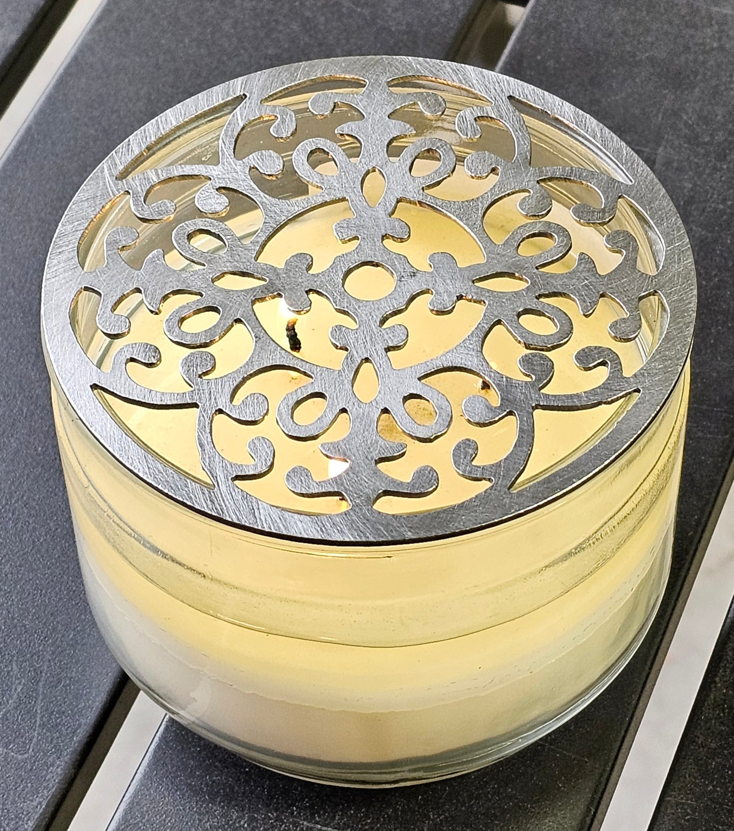 Vintage baroque metal candle topper with ornate scroll design on jar candle