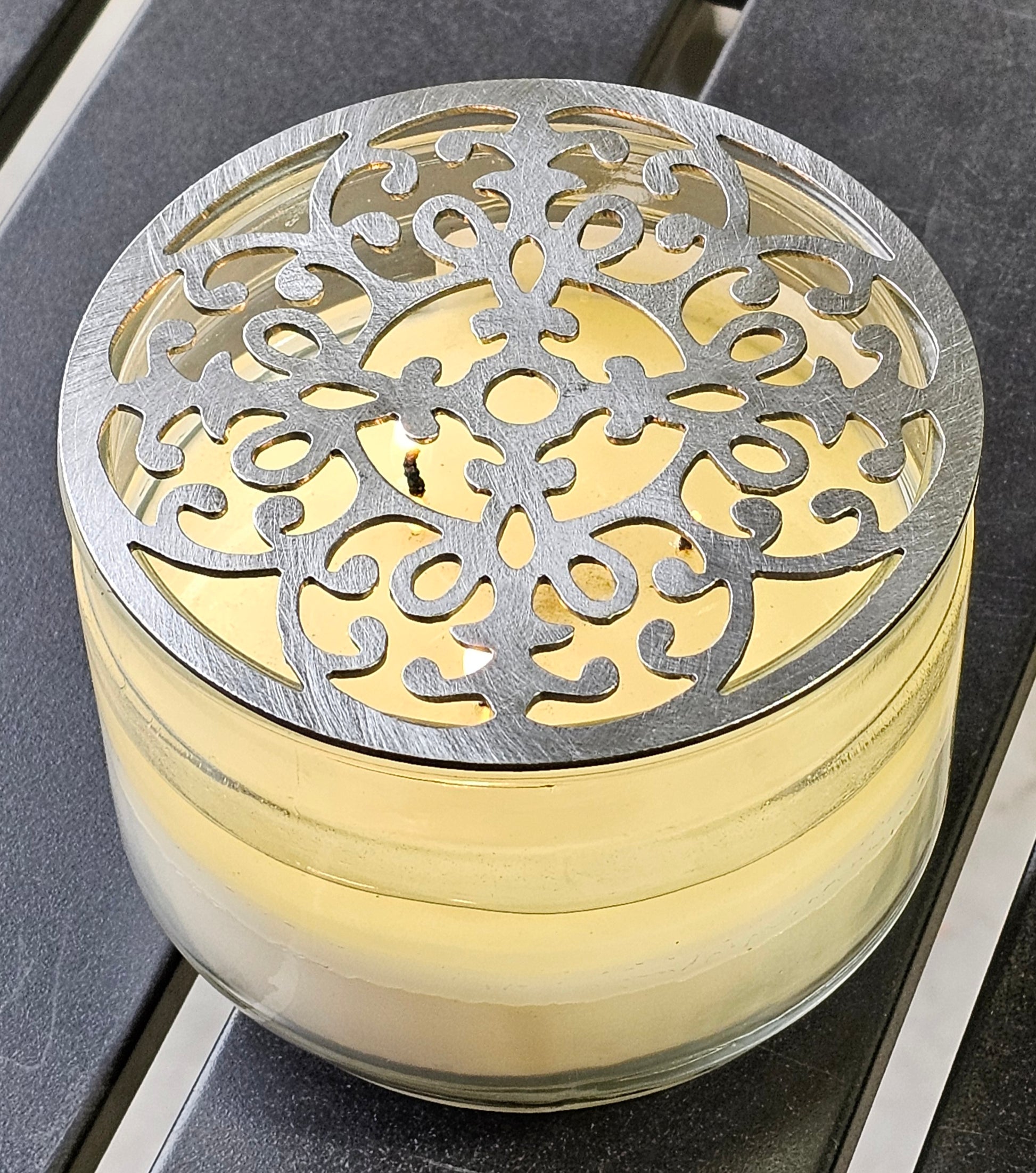 Vintage baroque metal candle topper with ornate scroll design on jar candle