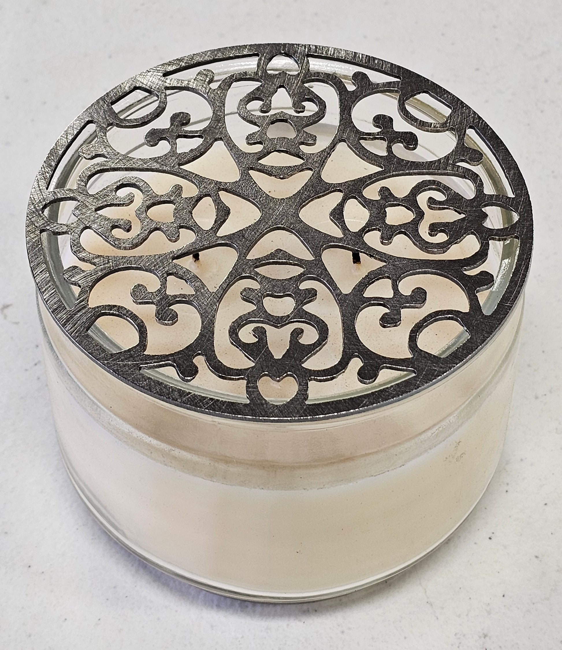 Metal filigree candle topper preventing tunneling