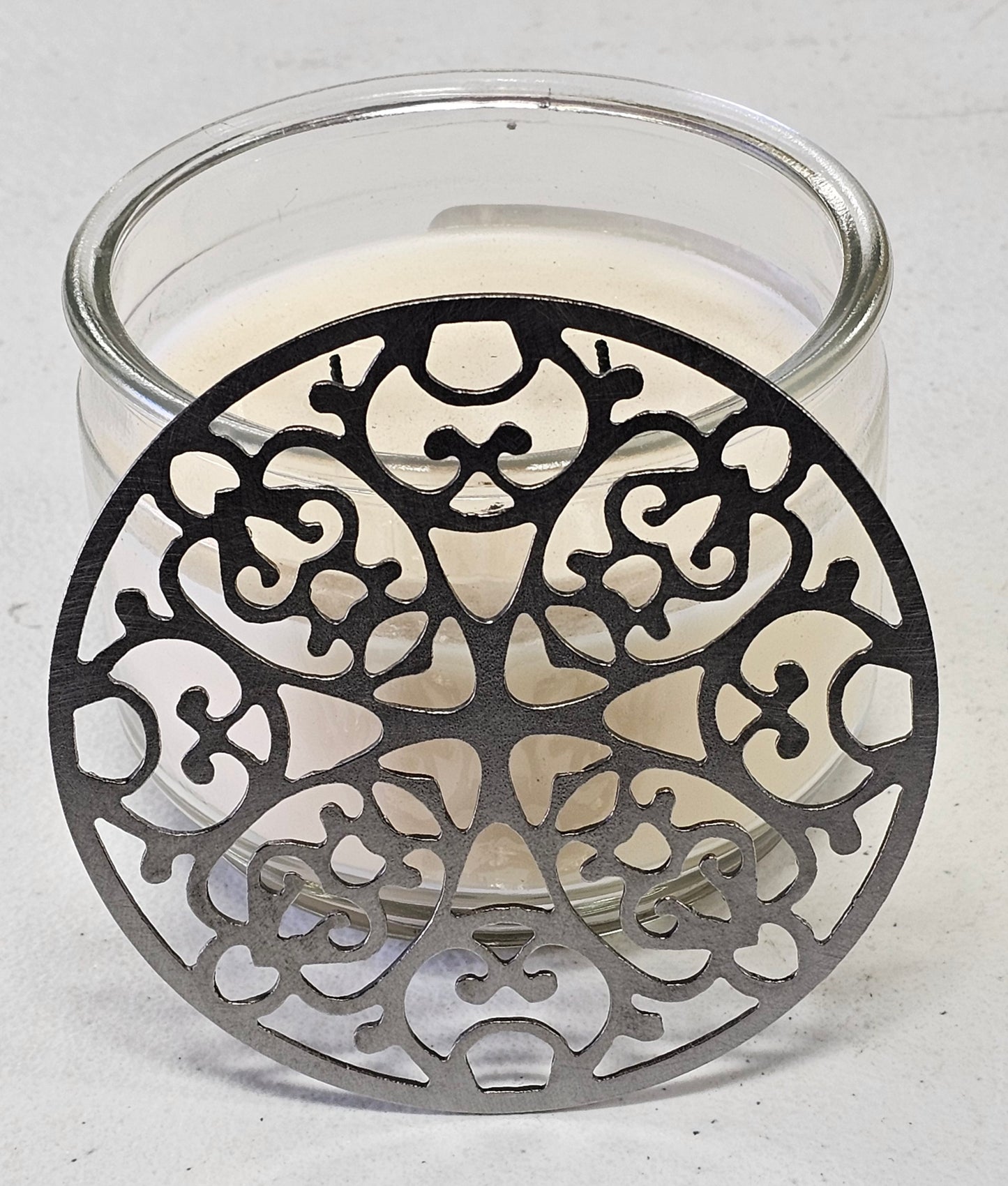 Metal filigree candle topper preventing tunneling
