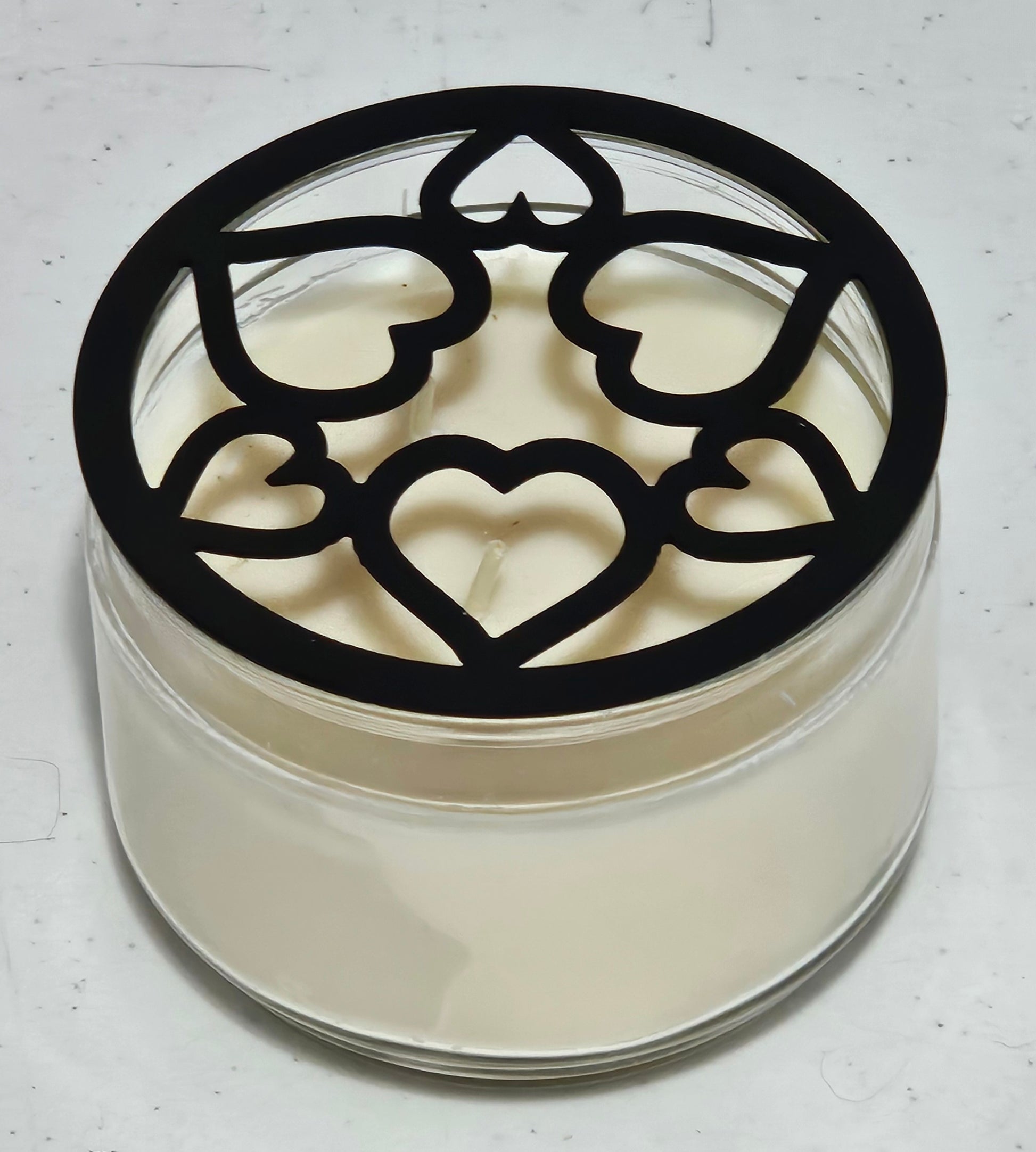 Tangled Hearts metal candle topper featuring intertwined heart design on a lit jar candle