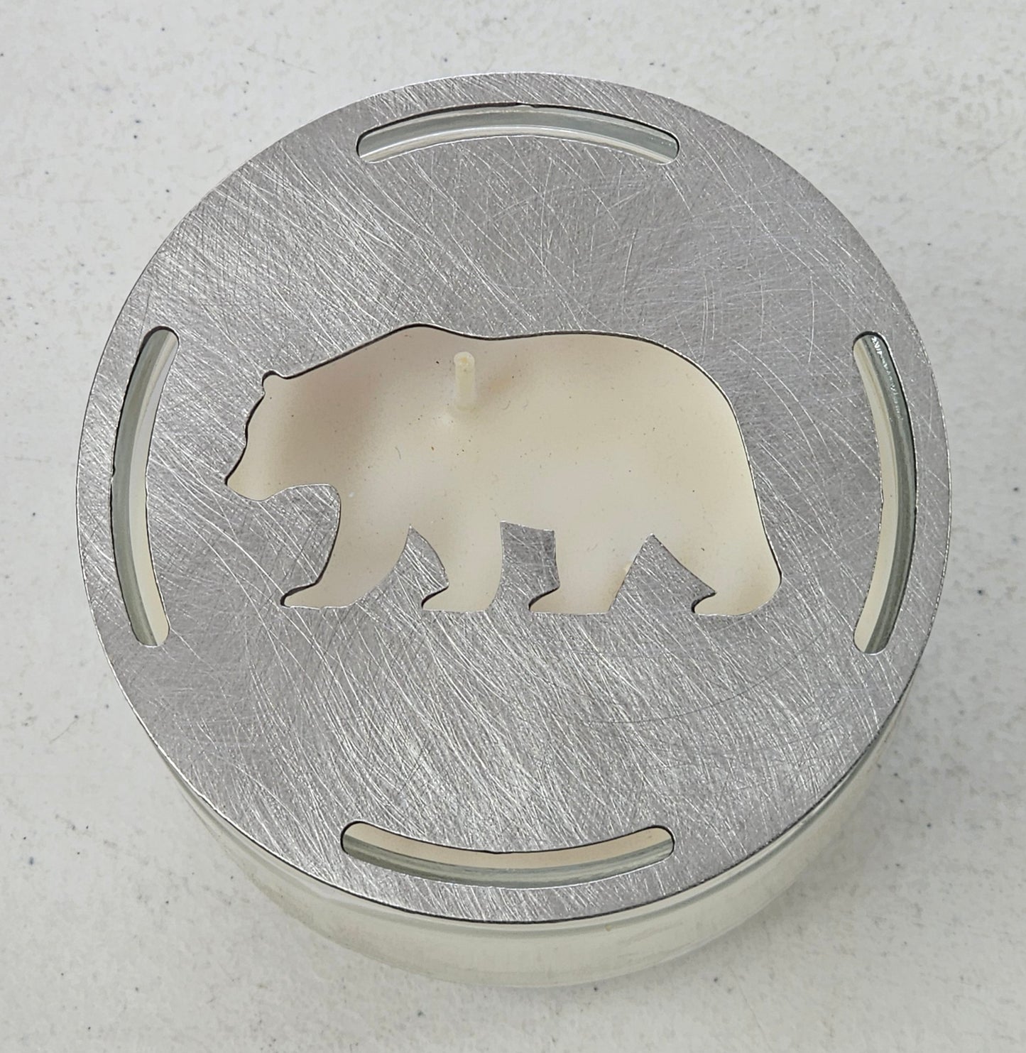 Rustic bear candle topper sitting flat on white jar candle showing wildlife silhouette design