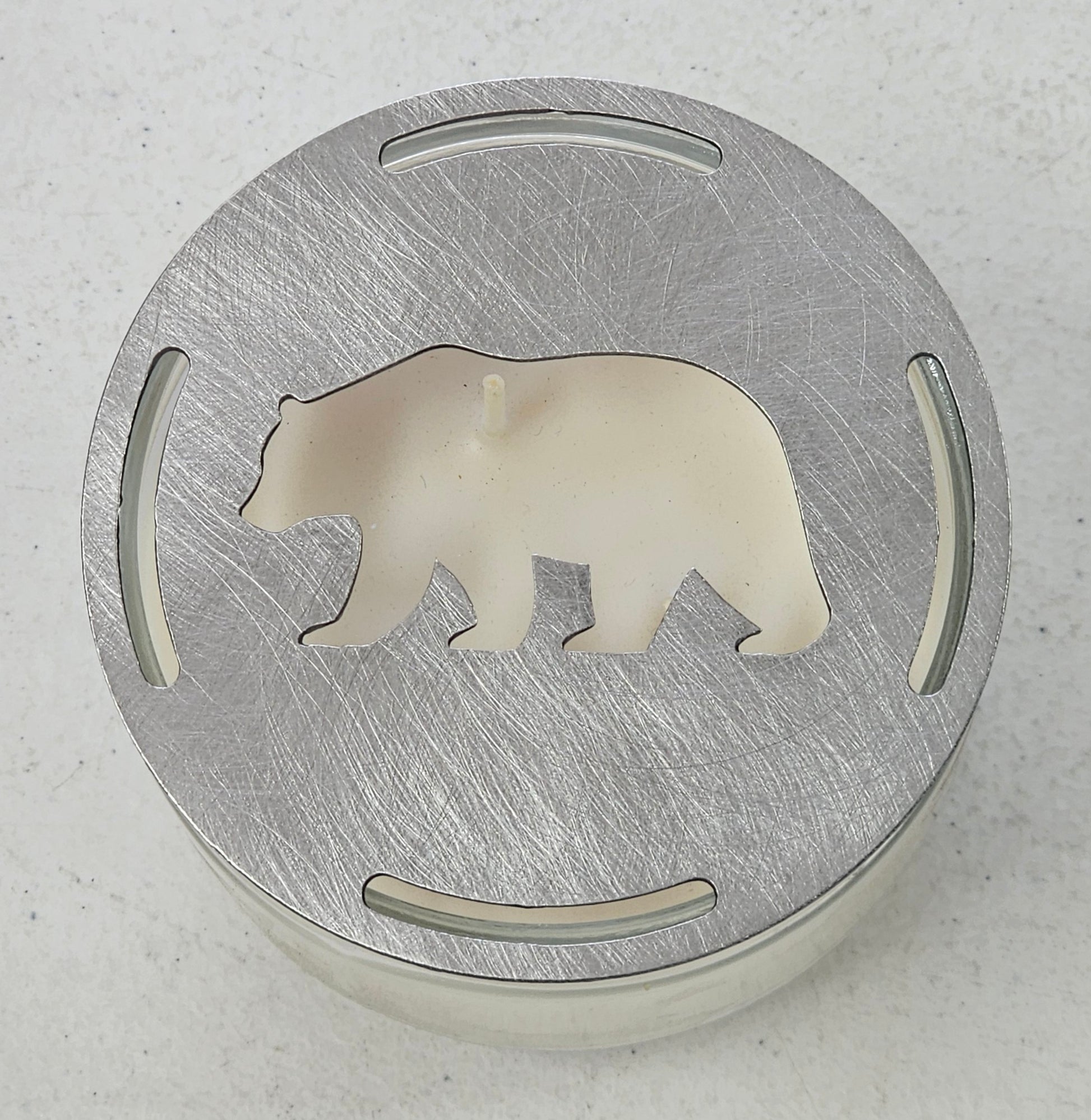 Rustic bear candle topper sitting flat on white jar candle showing wildlife silhouette design