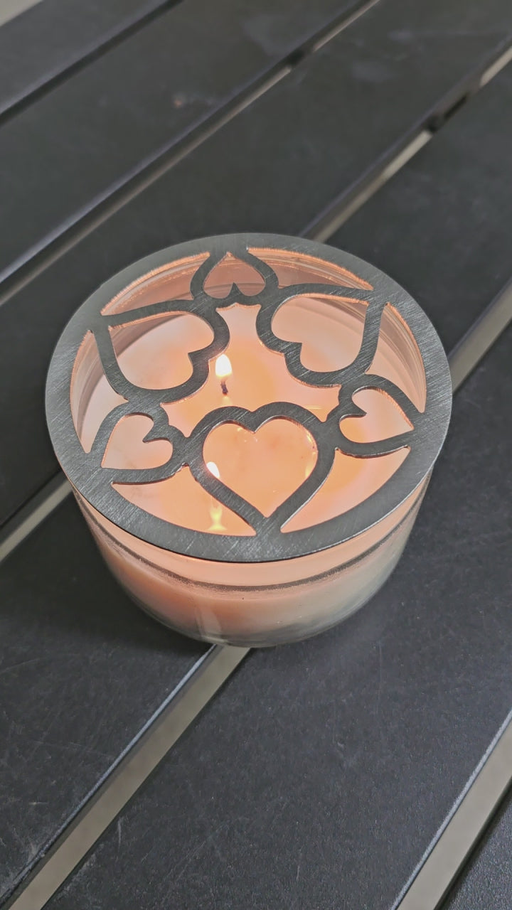 Tangled Hearts metal candle topper featuring intertwined heart design on a lit jar candle