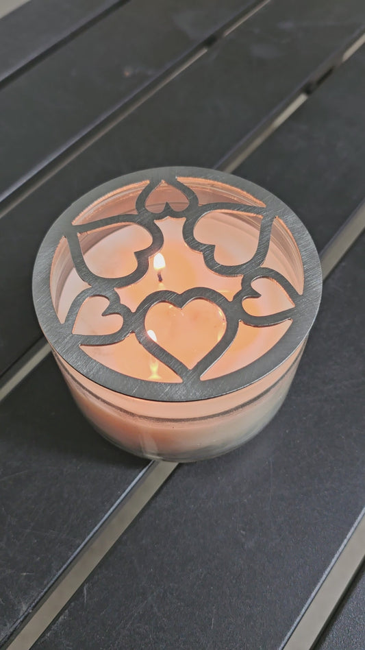 Tangled Hearts metal candle topper featuring intertwined heart design on a lit jar candle
