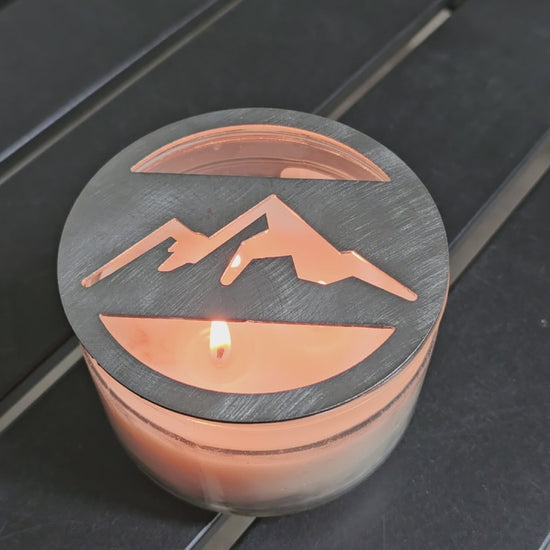 Mountain metal candle topper placed on white jar candle