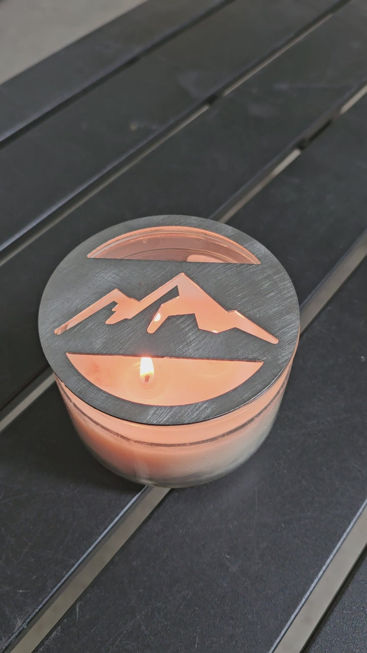 Mountain metal candle topper placed on white jar candle