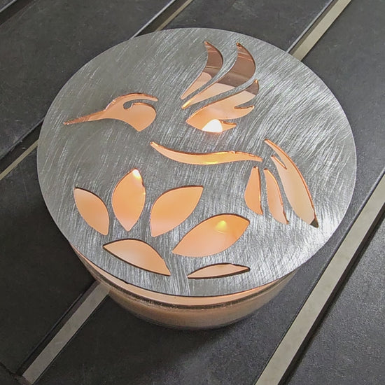 Hummingbird metal candle topper on 3-wick candle with cutout leaf design
