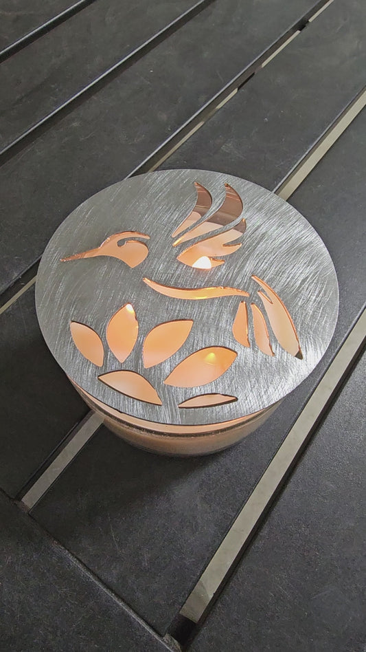 Hummingbird metal candle topper on 3-wick candle with cutout leaf design