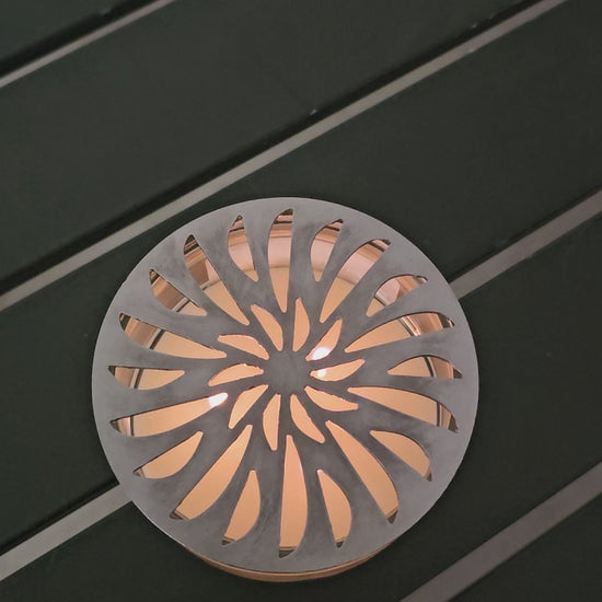 metal candle topper on jar candle glowing flame