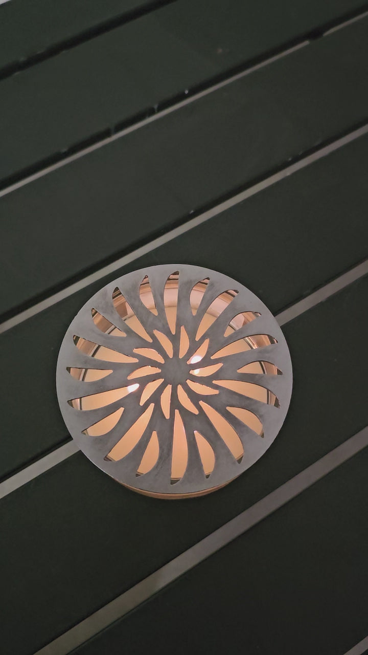 metal candle topper on jar candle glowing flame