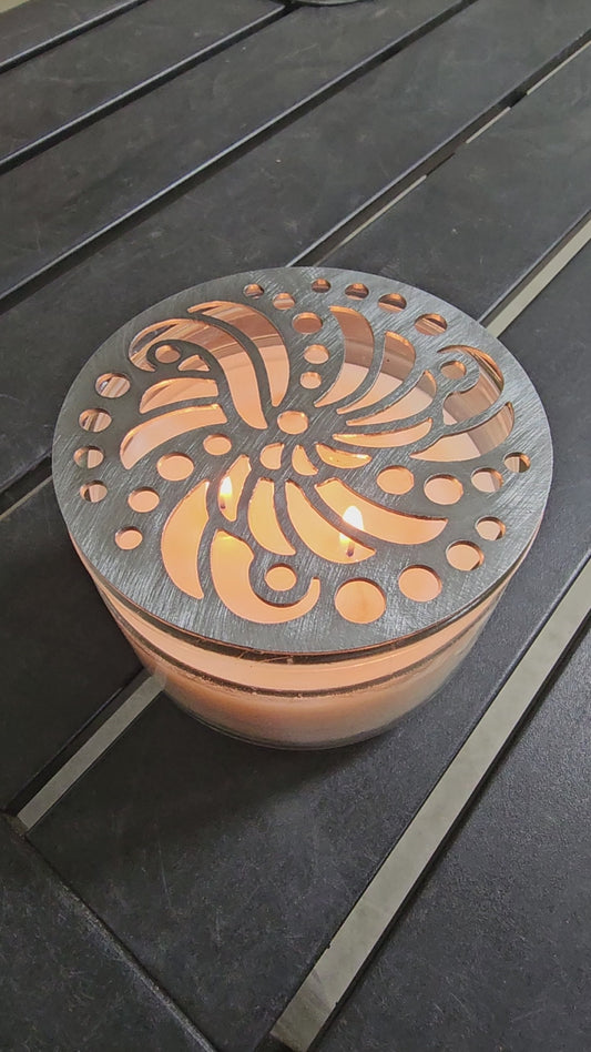 Luxury candle accessory with intricate cutout design casting soft light pattern.