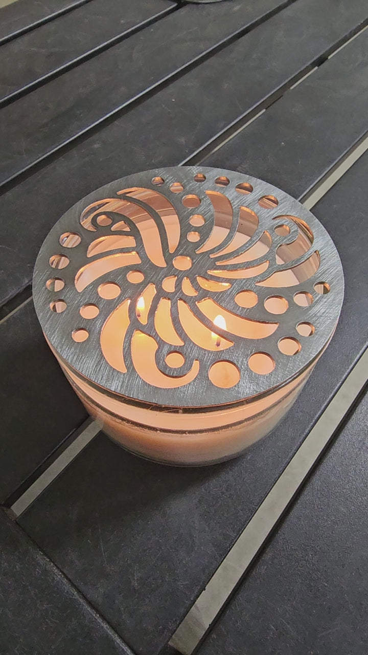 Luxury candle accessory with intricate cutout design casting soft light pattern.