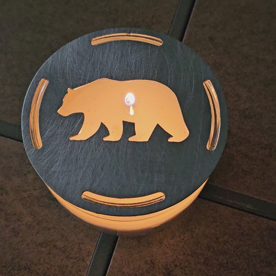 Rustic bear candle topper sitting flat on white jar candle showing wildlife silhouette design