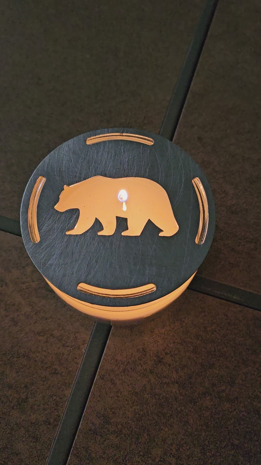 Rustic bear candle topper sitting flat on white jar candle showing wildlife silhouette design