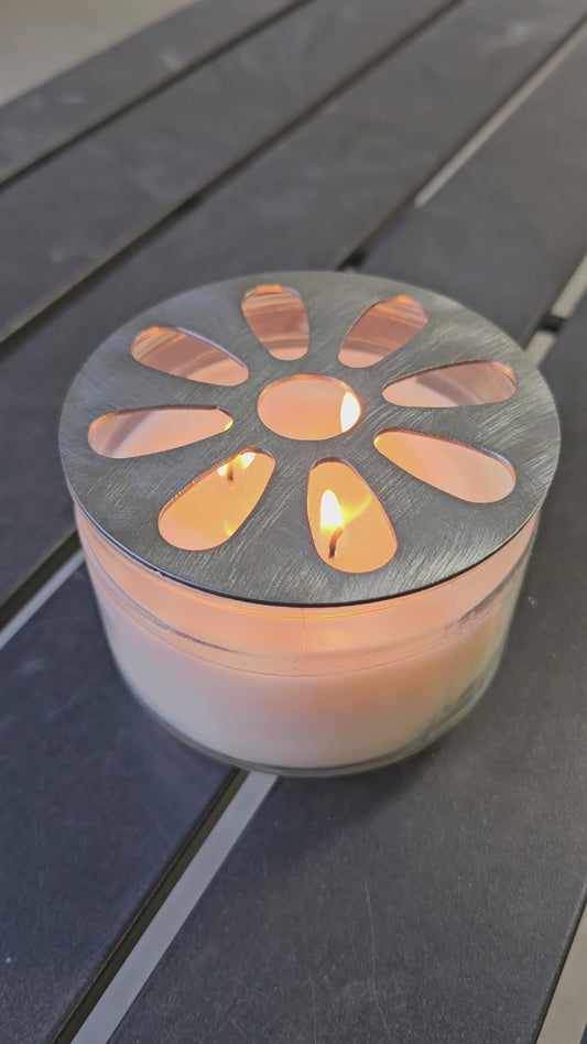 Flower pattern metal candle topper on jar candle creating warm glow and even burn