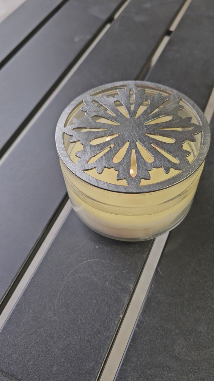 Nordic snowflake metal candle topper placed on white jar candle